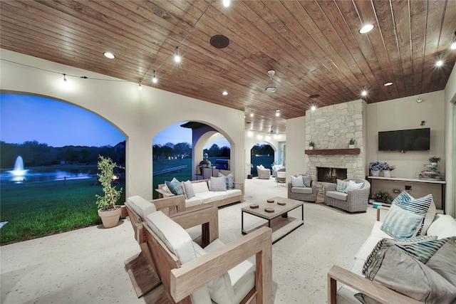 view of patio featuring a water view and an outdoor living space with a fireplace