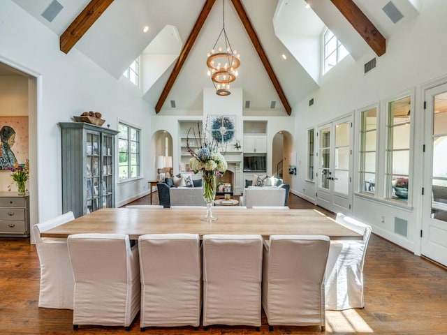 interior space featuring visible vents, an inviting chandelier, beamed ceiling, high vaulted ceiling, and arched walkways