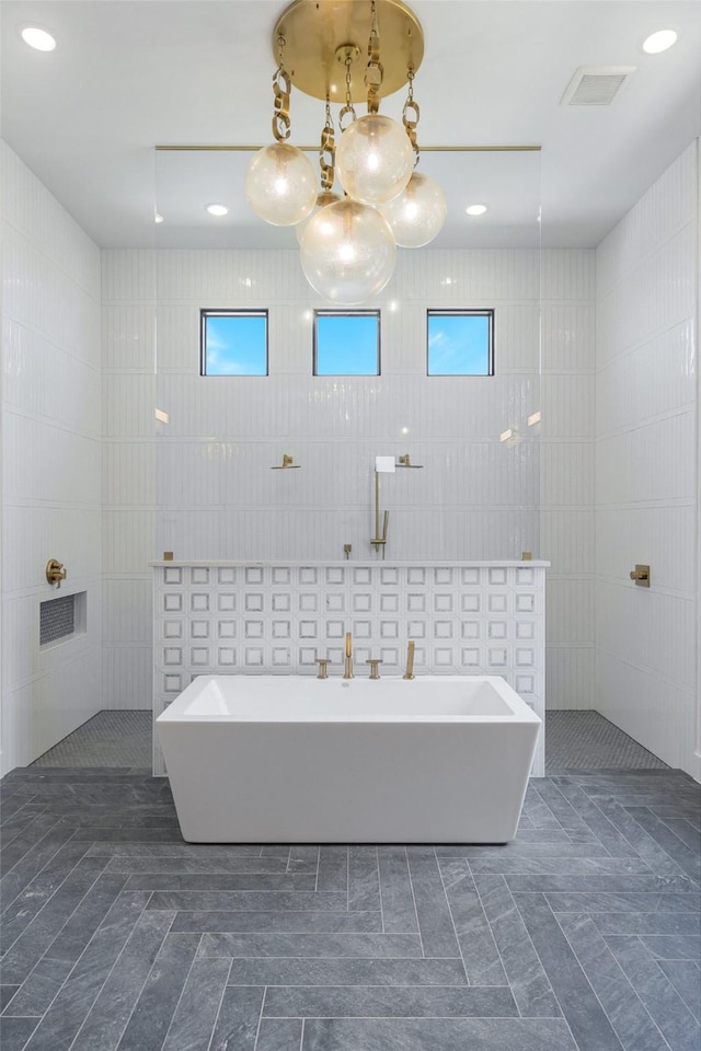 12479 Palmer Dr, Fort Worth, TX 76179 - bathroom with tile walls, a freestanding bath, a chandelier, a walk in shower, and recessed lighting