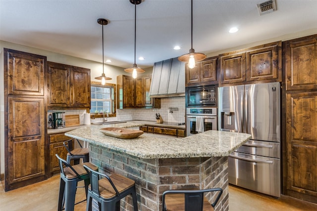 kitchen with light stone countertops, a breakfast bar, backsplash, a kitchen island, and black appliances