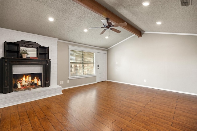 unfurnished living room featuring lofted ceiling with beams, a fireplace, wood finished floors, visible vents, and ceiling fan