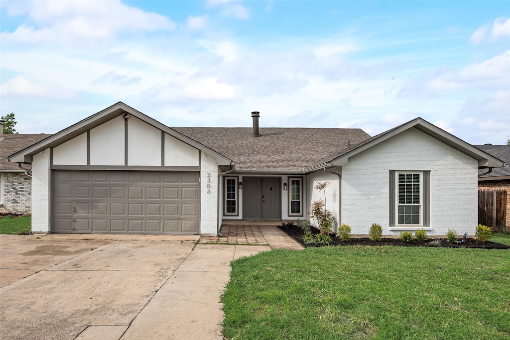 2303 Sharpshire Ln, Arlington, TX 76014 - single story home featuring roof with shingles, driveway, a front yard, brick siding, and a garage