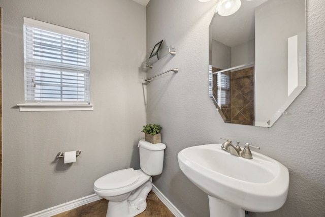 8312 Rancho De La Osa Trl, Mckinney, TX 75070 - bathroom featuring toilet, a sink, tiled shower, and baseboards