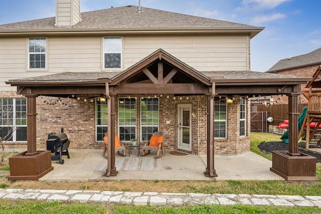 8312 Rancho De La Osa Trl, Mckinney, TX 75070 - rear view of property featuring a patio, brick siding, a chimney, and a playground