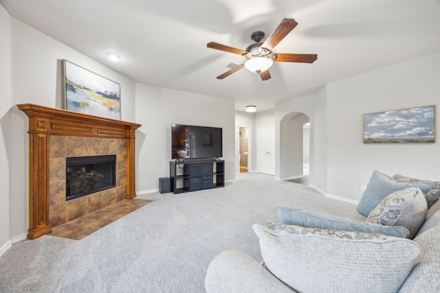 8312 Rancho De La Osa Trl, Mckinney, TX 75070 - carpeted living area featuring ceiling fan, arched walkways, a tile fireplace, and baseboards