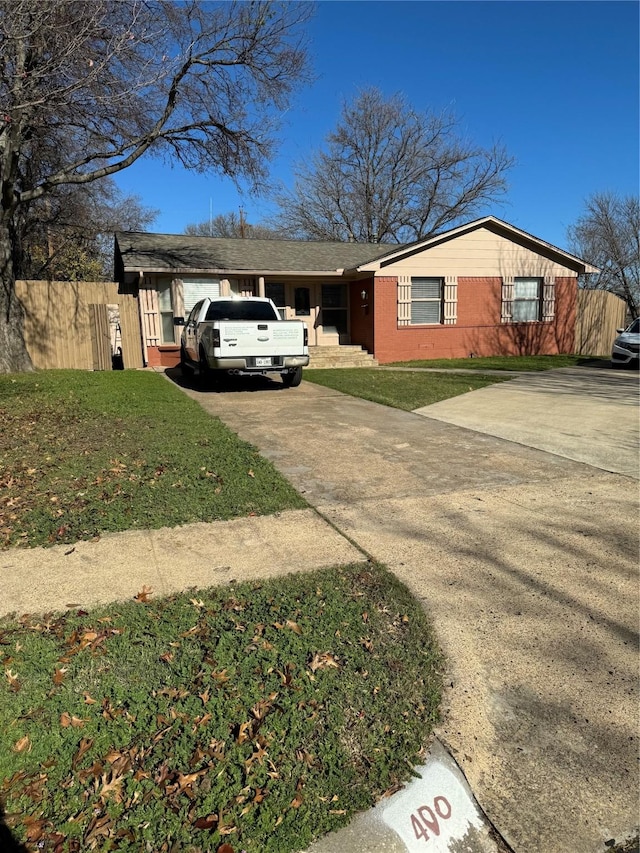 view of side of property featuring fence, concrete driveway, and a yard