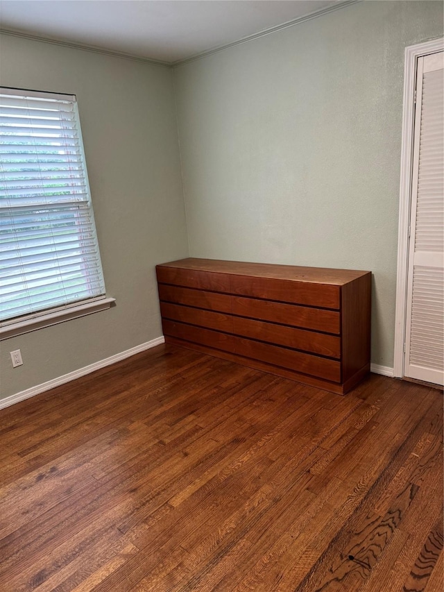 unfurnished room featuring baseboards and wood finished floors