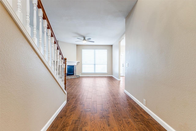 2104 Aberdeen Ave, Mckinney, TX 75072 - unfurnished living room featuring a ceiling fan, dark wood-type flooring, a textured wall, and a fireplace