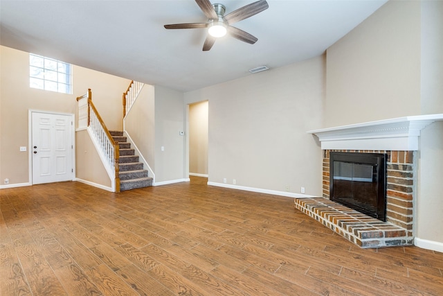 2104 Aberdeen Ave, Mckinney, TX 75072 - unfurnished living room with a ceiling fan, stairs, wood finished floors, and a brick fireplace