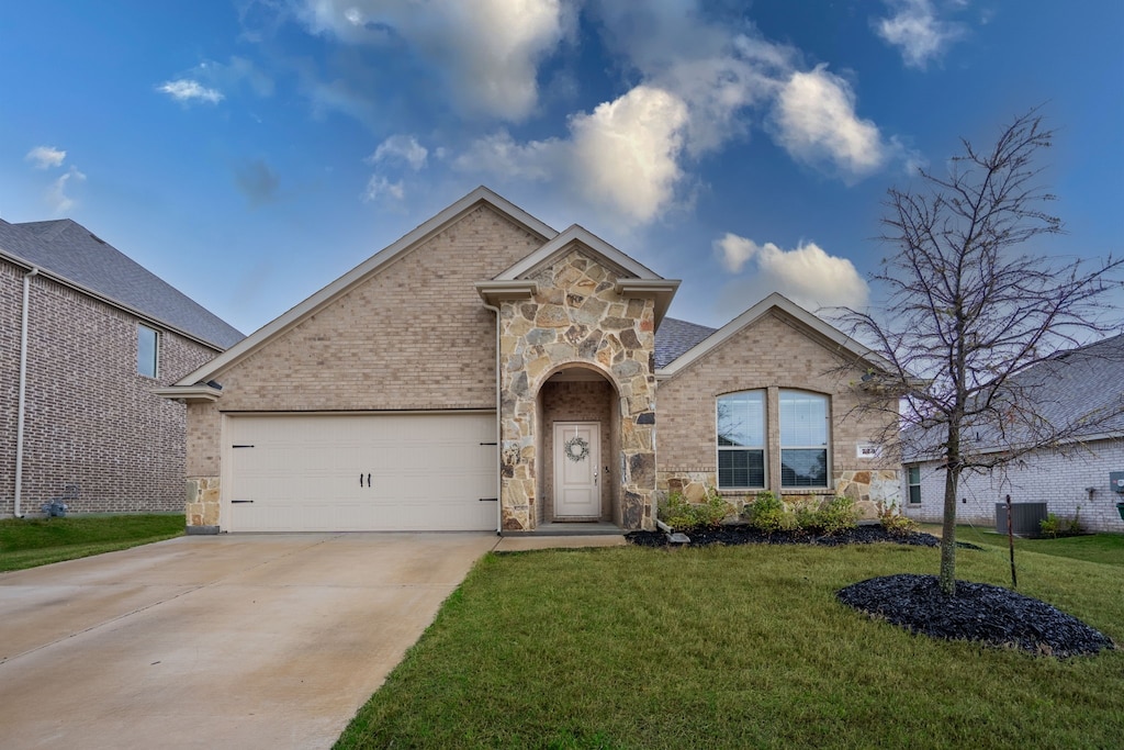view of front of house with concrete driveway, an attached garage, stone siding, a front yard, and brick siding