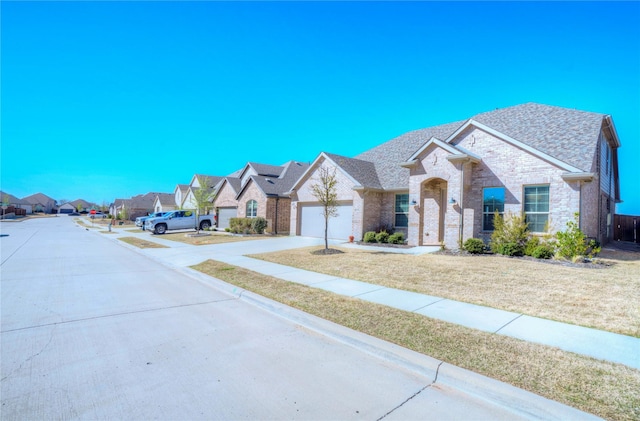 french country style house with driveway, a residential view, a shingled roof, brick siding, and a garage