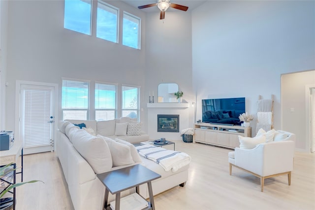 1208 Arcadia Ln, Northlake, TX 76226 - living area featuring a towering ceiling, ceiling fan, wood finished floors, and a glass covered fireplace