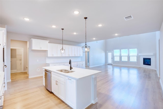 1208 Arcadia Ln, Northlake, TX 76226 - kitchen with a sink, stainless steel dishwasher, an island with sink, light wood-type flooring, and baseboards
