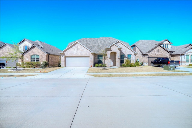 french country inspired facade with a garage, brick siding, and driveway