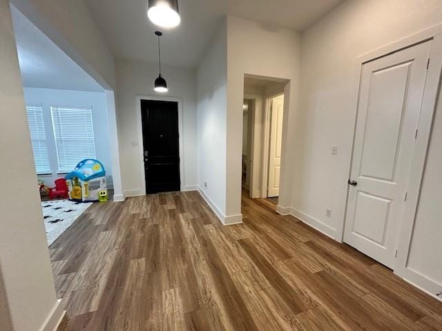 foyer entrance featuring baseboards and wood finished floors