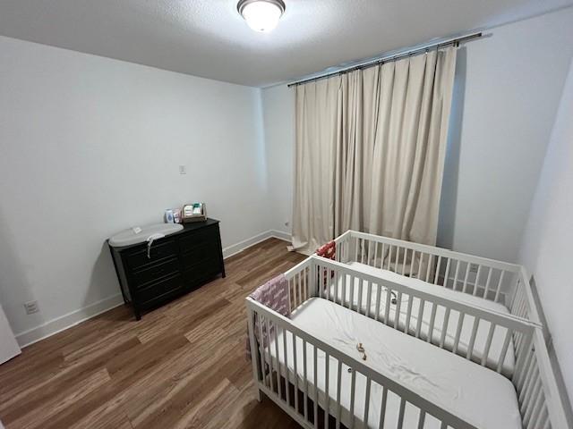 bedroom with baseboards and wood finished floors