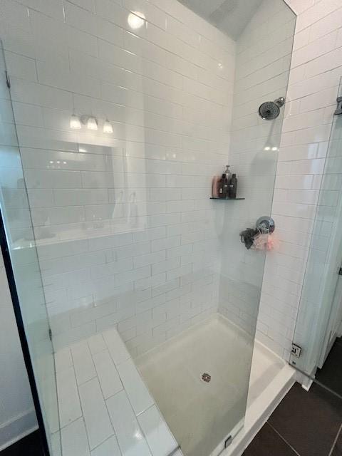 bathroom with tile patterned flooring and a stall shower