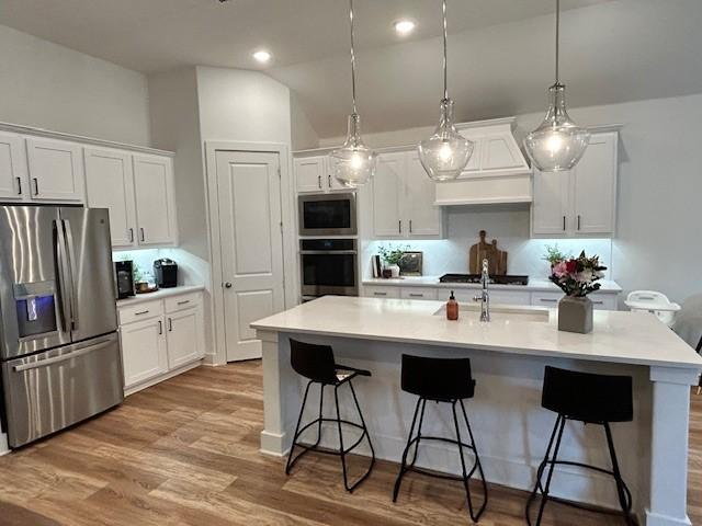 kitchen featuring a breakfast bar area, white cabinets, and appliances with stainless steel finishes