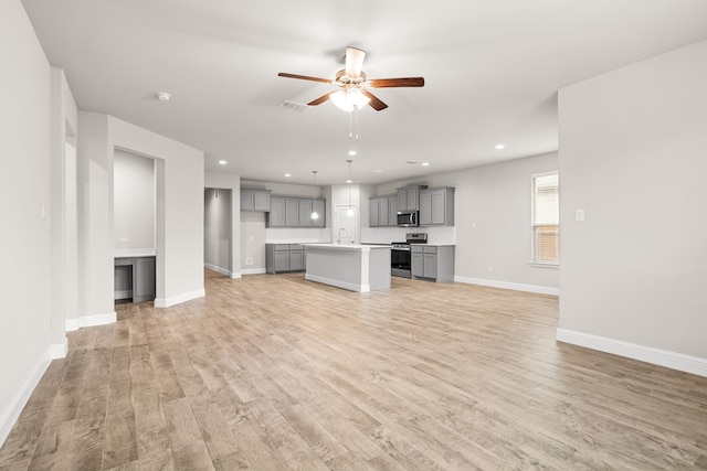825 Blackhorse Trl, Fort Worth, TX 76247 - unfurnished living room featuring light wood-style floors, a ceiling fan, baseboards, recessed lighting, and a sink