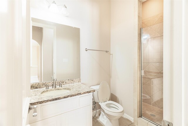 bathroom with tile patterned flooring, vanity, toilet, baseboards, and a stall shower