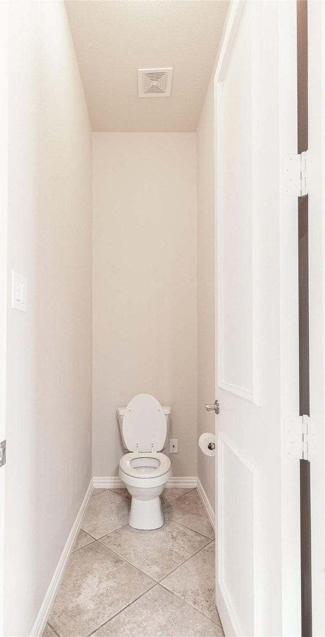bathroom with toilet, tile patterned flooring, baseboards, and visible vents