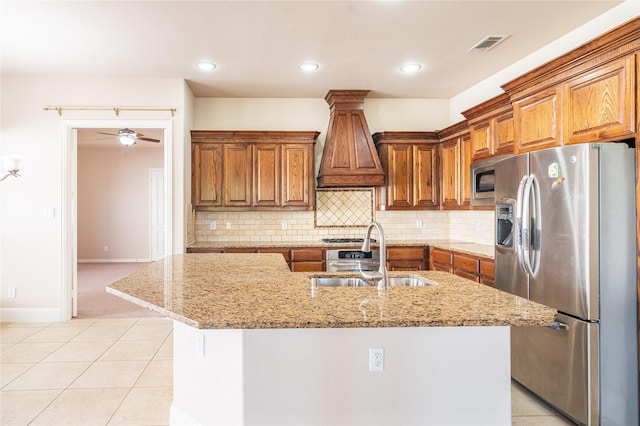 kitchen featuring a sink, brown cabinetry, custom exhaust hood, and appliances with stainless steel finishes