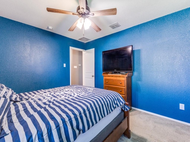 bedroom with a textured wall, a ceiling fan, baseboards, visible vents, and carpet