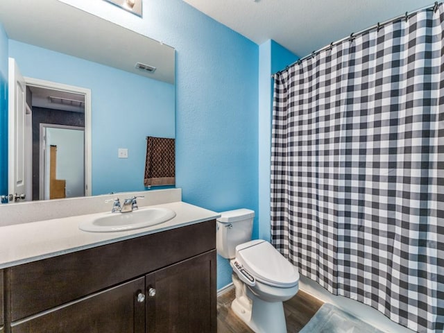 bathroom with visible vents, toilet, wood finished floors, vanity, and a shower with curtain