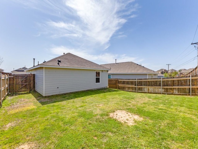 rear view of house featuring a fenced backyard and a yard