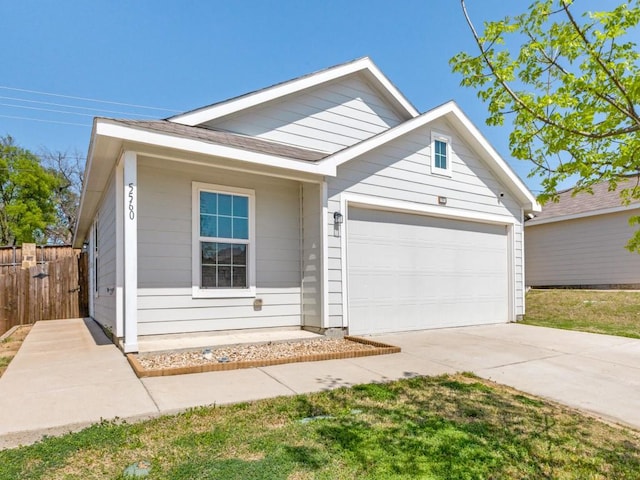 view of front of house with driveway, fence, and a garage