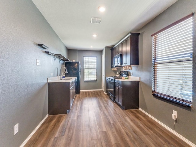interior space with baseboards, dark wood-style flooring, visible vents, and a sink