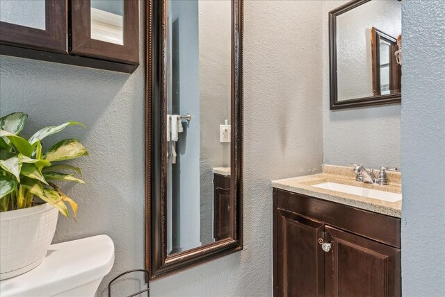 405 Rosewood Hills Dr, Garland, TX 75040 - bathroom with a textured wall, toilet, and vanity