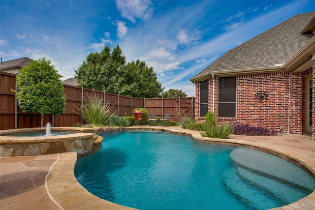 view of swimming pool featuring a pool with connected hot tub and a fenced backyard