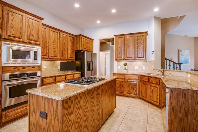 kitchen featuring brown cabinetry, a sink, appliances with stainless steel finishes, and backsplash