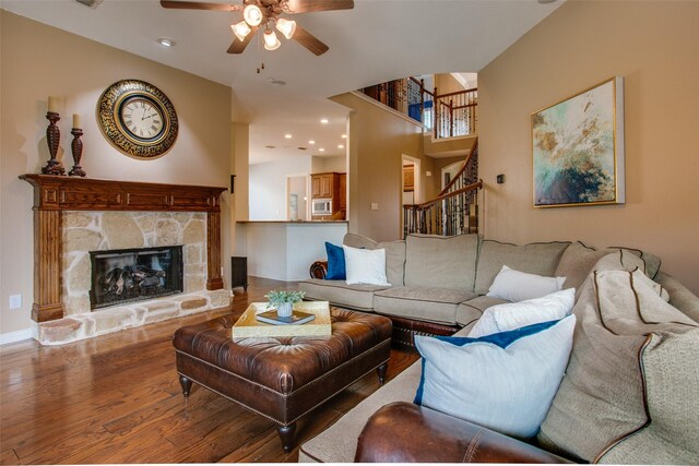 living area with a ceiling fan, a fireplace, stairs, wood finished floors, and recessed lighting