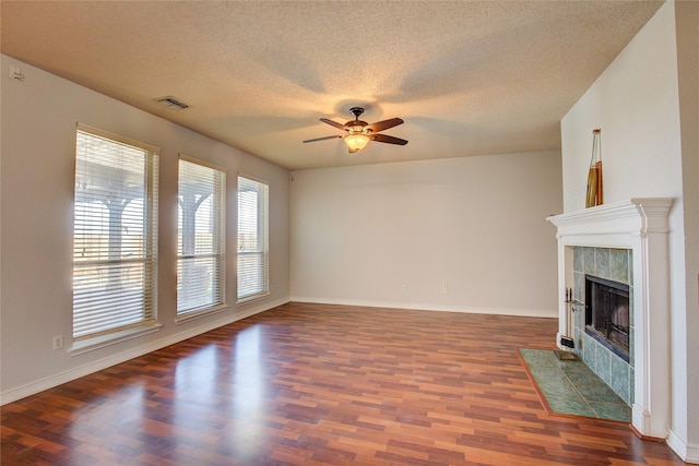 3331 Midstream Ct, Mesquite, TX 75181 - unfurnished living room with a ceiling fan, dark wood-type flooring, a fireplace, a textured ceiling, and baseboards