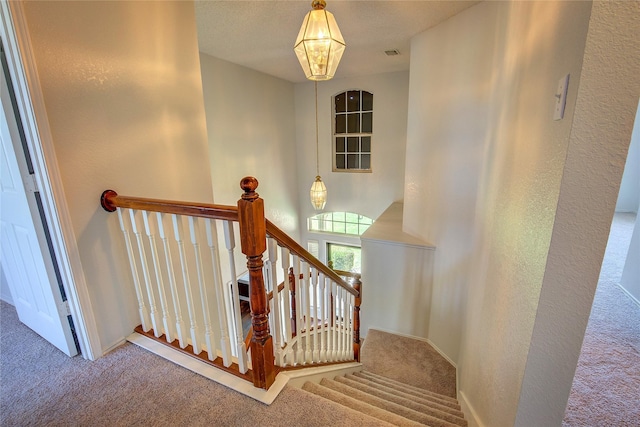 3331 Midstream Ct, Mesquite, TX 75181 - staircase featuring carpet flooring, a textured wall, baseboards, and a chandelier