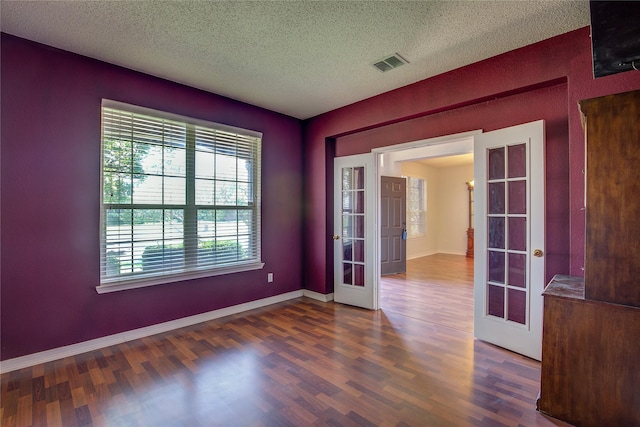 3331 Midstream Ct, Mesquite, TX 75181 - empty room featuring french doors, healthy amount of natural light, wood finished floors, and a textured ceiling