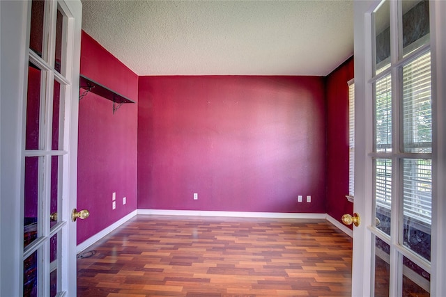 3331 Midstream Ct, Mesquite, TX 75181 - unfurnished room featuring plenty of natural light, wood finished floors, a textured ceiling, and baseboards