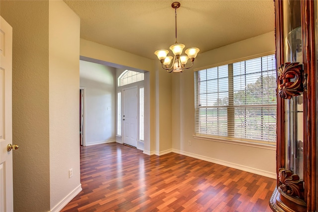 3331 Midstream Ct, Mesquite, TX 75181 - foyer with dark wood-style floors, a chandelier, plenty of natural light, baseboards, and a textured ceiling
