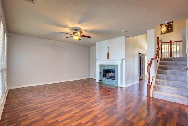 3331 Midstream Ct, Mesquite, TX 75181 - unfurnished living room featuring dark wood-type flooring, a ceiling fan, stairs, baseboards, and a textured ceiling