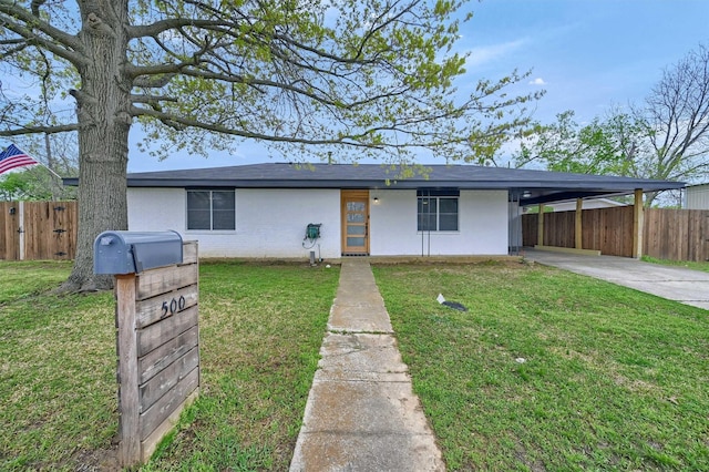 view of front of home with an attached carport, a front yard, fence, and driveway