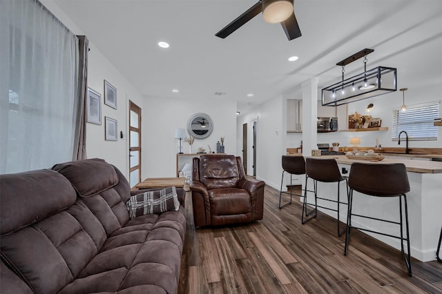 living room with baseboards, ceiling fan, recessed lighting, and dark wood-style flooring