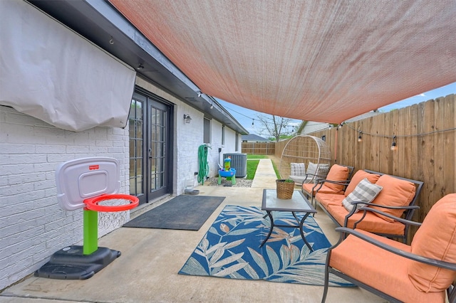 view of patio / terrace featuring a fenced backyard, central AC unit, and outdoor lounge area