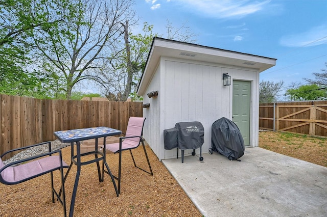 view of patio / terrace featuring a fenced backyard, an outdoor structure, and area for grilling