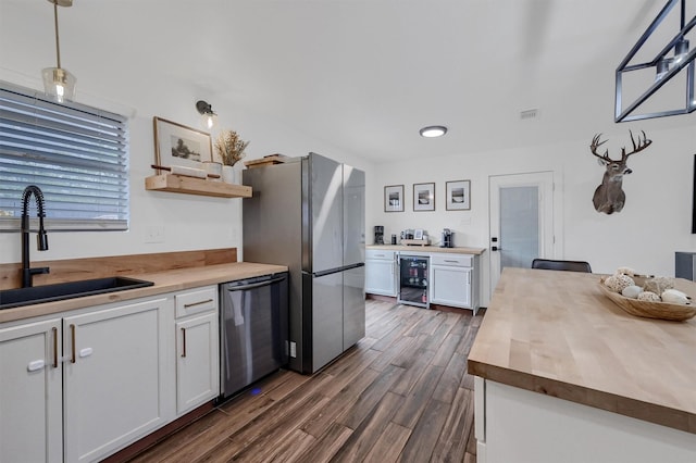 kitchen with a sink, open shelves, butcher block countertops, beverage cooler, and stainless steel appliances