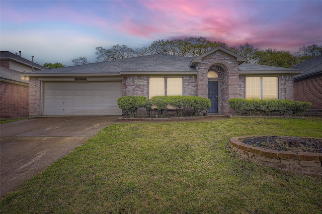 ranch-style home featuring a front yard, an attached garage, brick siding, and driveway