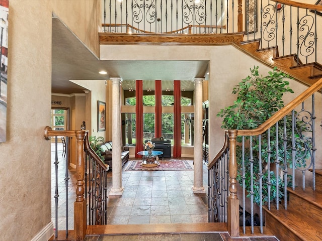9 Eagle Pt N Unit A, Azle, TX 76020 - entrance foyer featuring a towering ceiling, stone tile floors, ornate columns, baseboards, and ornamental molding
