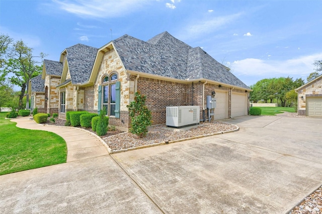 7545 Colton Ln, Pilot Point, TX 76258 - view of home's exterior featuring stone siding, concrete driveway, a garage, cooling unit, and brick siding