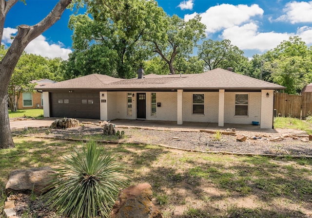 1018 Brookhollow Dr, Irving, TX 75061 - view of front of home with brick siding, an attached garage, fence, driveway, and roof with shingles